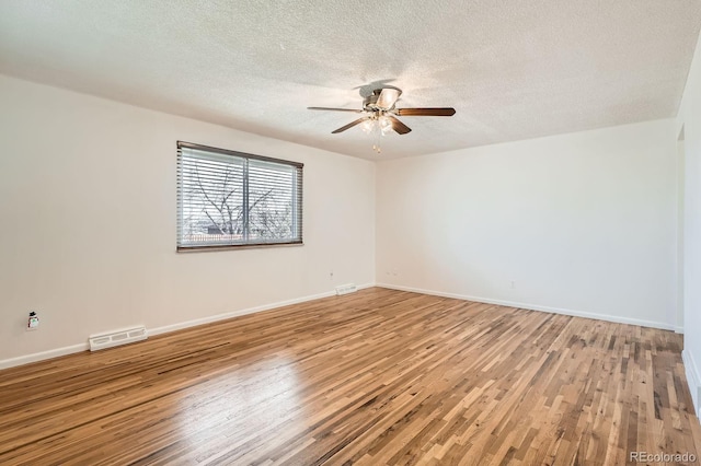 unfurnished room with a textured ceiling, visible vents, baseboards, ceiling fan, and light wood-type flooring