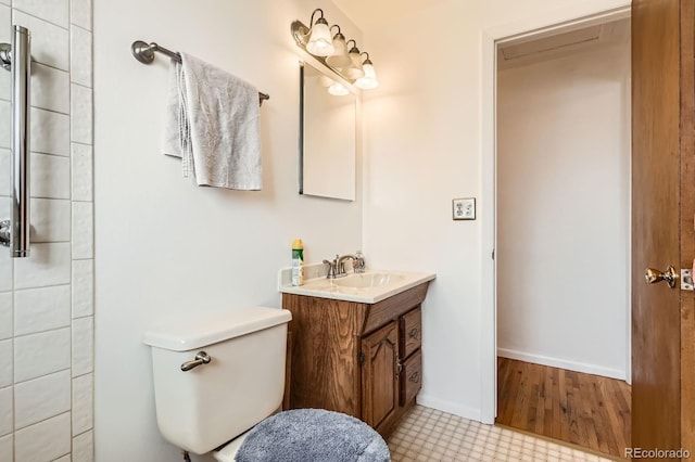 bathroom featuring baseboards, toilet, and vanity