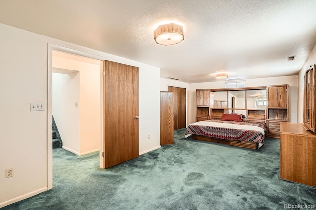 bedroom featuring visible vents, carpet, baseboards, and a textured ceiling