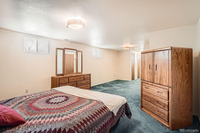 bedroom with dark colored carpet and a textured ceiling