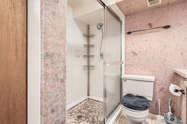 bathroom with toilet, a shower stall, and visible vents