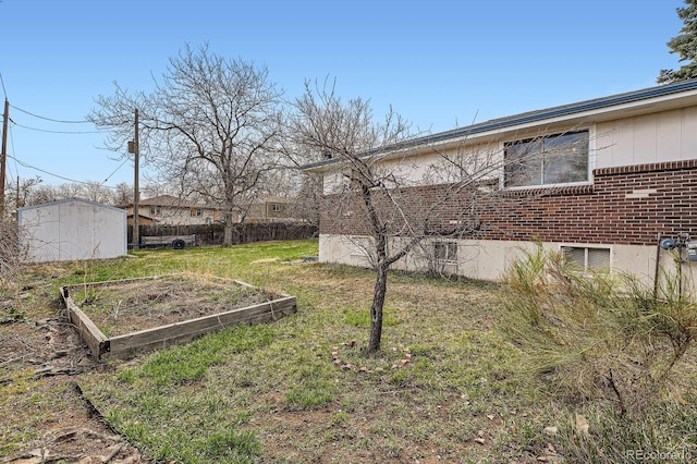view of yard with an outbuilding, fence, and a vegetable garden