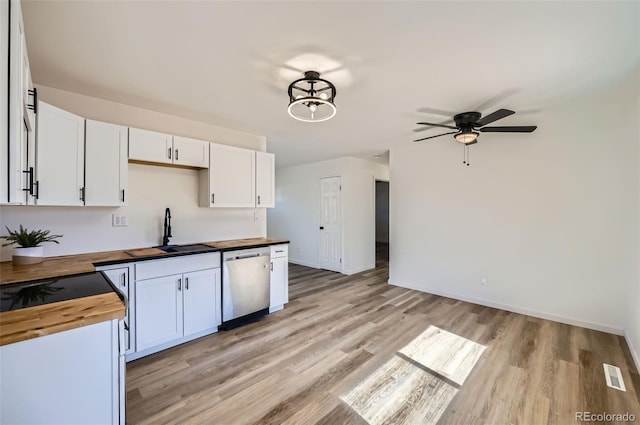 kitchen featuring visible vents, white cabinets, butcher block countertops, stainless steel dishwasher, and a sink