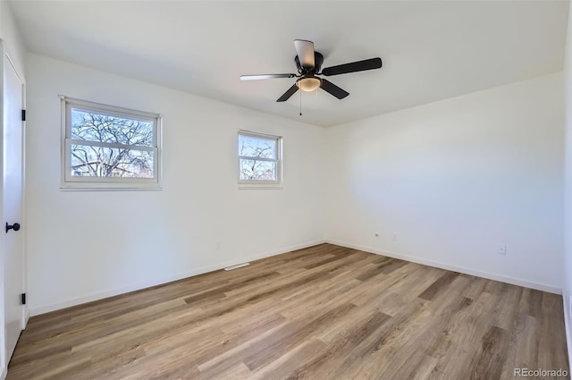 unfurnished room with light wood-type flooring, visible vents, baseboards, and a ceiling fan