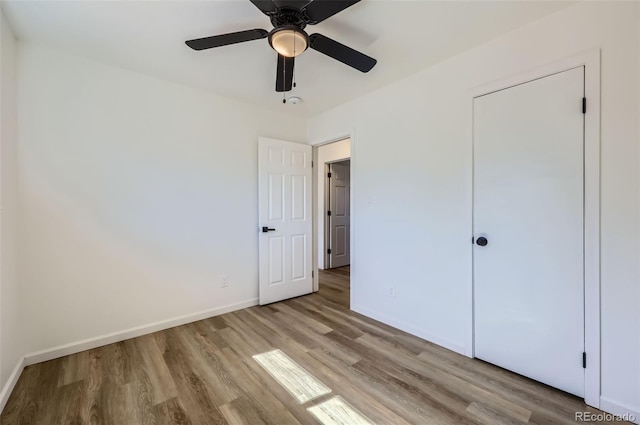 unfurnished bedroom with a ceiling fan, baseboards, and wood finished floors