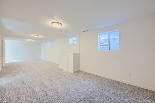 basement featuring carpet, visible vents, and baseboards