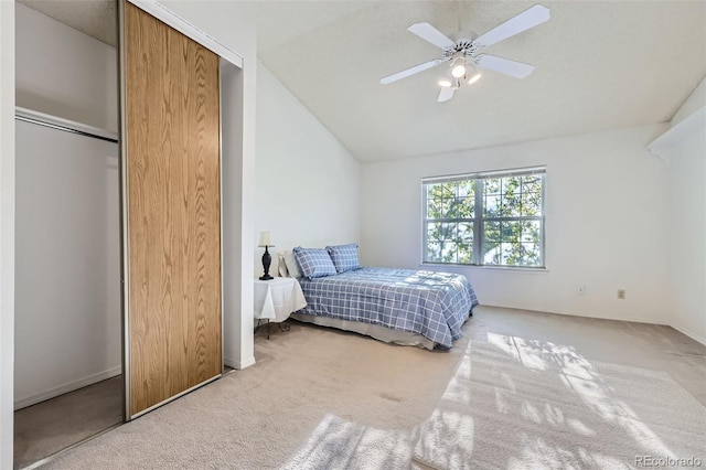 carpeted bedroom featuring lofted ceiling, baseboards, ceiling fan, and a closet