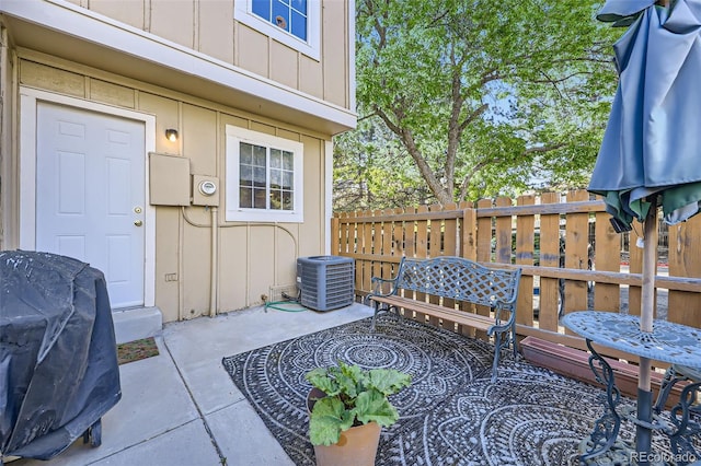 view of patio featuring central AC unit and fence
