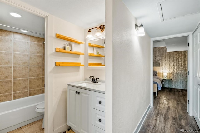 ensuite bathroom with vanity, wood finished floors, shower / bath combination, toilet, and connected bathroom