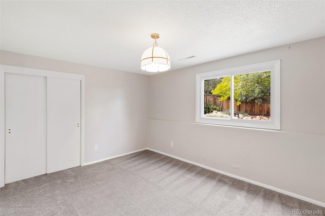 2434 Virgo Dr, Colorado Springs, CO 80906 - unfurnished bedroom featuring carpet flooring, a closet, and a textured ceiling