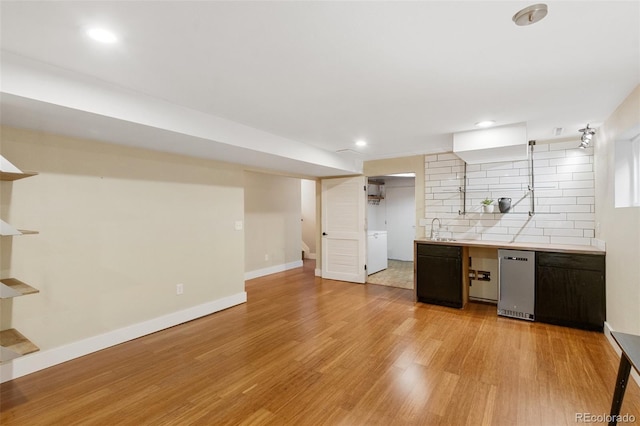 2434 Virgo Dr, Colorado Springs, CO 80906 - kitchen featuring light wood-style flooring, decorative backsplash, light countertops, recessed lighting, and washer / clothes dryer