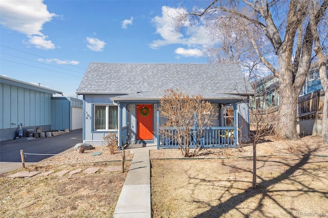 view of front of property with covered porch, a shingled roof, fence, and aphalt driveway