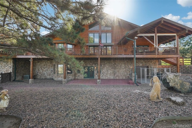 3557 Palmer Ridge Dr, Parker, CO 80134 - rear view of house with stone siding, a patio, central AC unit, and a deck