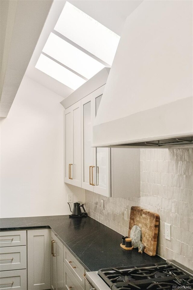 40 S Dexter St, Denver, CO 80246 - kitchen featuring custom exhaust hood, white cabinets, dark countertops, and tasteful backsplash