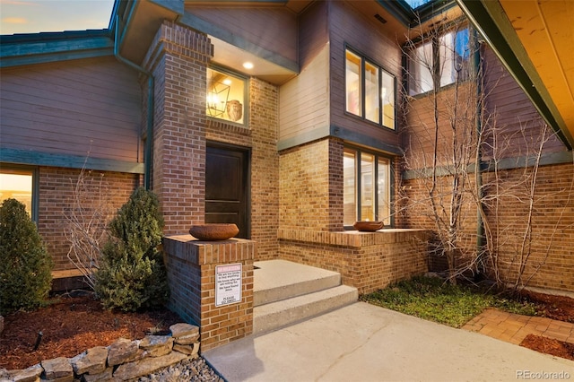 doorway to property featuring brick siding