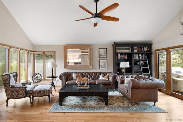 living area with a ceiling fan, light wood-style floors, and high vaulted ceiling