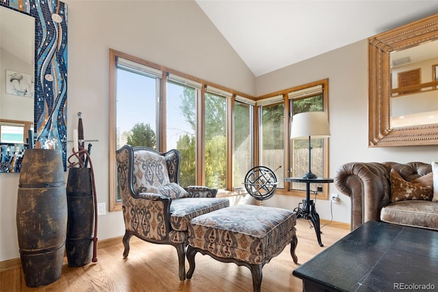 sitting room with vaulted ceiling, light wood-style flooring, and baseboards