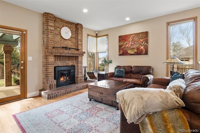 living area featuring a wealth of natural light, a brick fireplace, wood finished floors, and recessed lighting