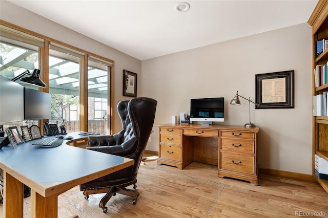 office area with light wood-style floors and baseboards