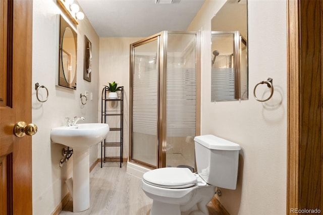 full bathroom featuring visible vents, a shower stall, baseboards, toilet, and wood finished floors