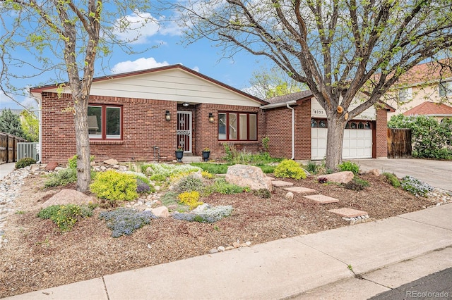 6235 W Floyd Ave, Denver, CO 80227 - view of front of home with driveway, brick siding, and an attached garage