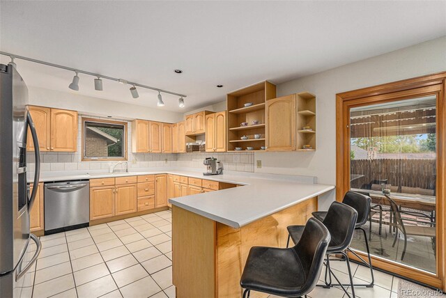 6235 W Floyd Ave, Denver, CO 80227 - kitchen featuring stainless steel appliances, open shelves, a peninsula, and light tile patterned floors