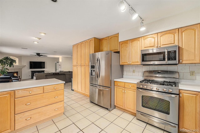 6235 W Floyd Ave, Denver, CO 80227 - kitchen featuring appliances with stainless steel finishes, light countertops, a ceiling fan, open floor plan, and a warm lit fireplace