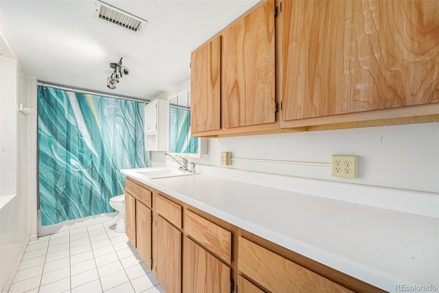 6235 W Floyd Ave, Denver, CO 80227 - kitchen featuring a sink, light tile patterned floors, and light countertops