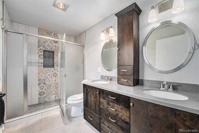 6235 W Floyd Ave, Denver, CO 80227 - full bathroom featuring toilet, a stall shower, double vanity, and wood finished floors