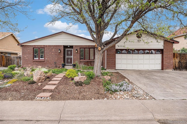 6235 W Floyd Ave, Denver, CO 80227 - ranch-style house featuring concrete driveway, an attached garage, and brick siding
