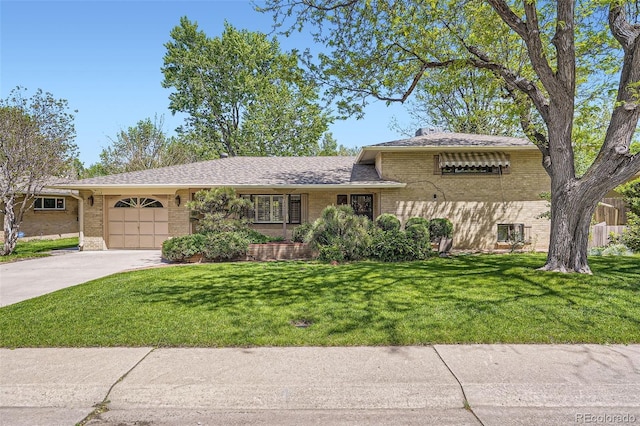 4490 Balsam St, Wheat Ridge, CO 80033 - split level home featuring brick siding, a garage, driveway, and a front lawn