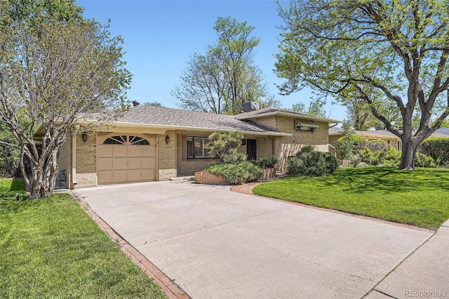 4490 Balsam St, Wheat Ridge, CO 80033 - tri-level home with concrete driveway, brick siding, a garage, and a front yard