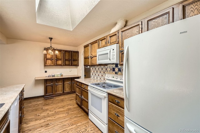 4490 Balsam St, Wheat Ridge, CO 80033 - kitchen with white appliances, light wood-style flooring, backsplash, and light countertops