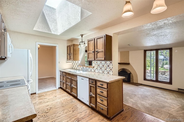 4490 Balsam St, Wheat Ridge, CO 80033 - kitchen with white appliances, brown cabinetry, a textured ceiling, light wood-style floors, and a sink