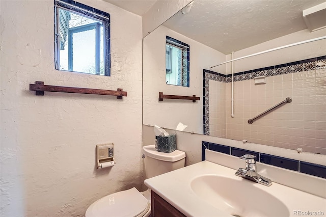 4490 Balsam St, Wheat Ridge, CO 80033 - bathroom with toilet, a textured wall, and vanity