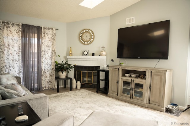 1358 S Irving St Unit A9, Denver, CO 80219 - living area with a skylight, a fireplace, vaulted ceiling, and wood finished floors