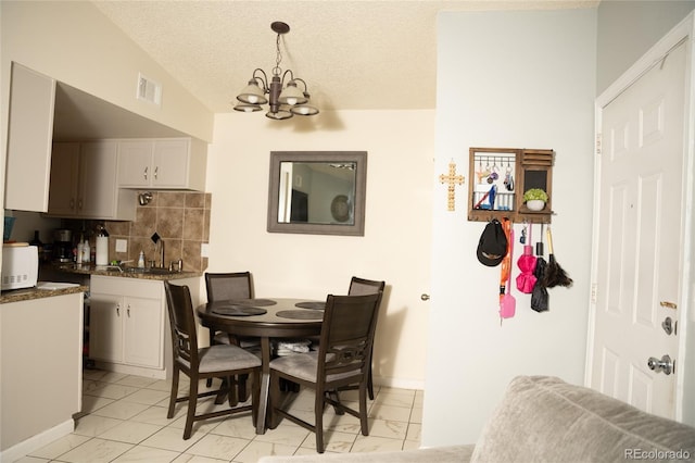 1358 S Irving St Unit A9, Denver, CO 80219 - dining space with a chandelier, light marble finish flooring, and a textured ceiling