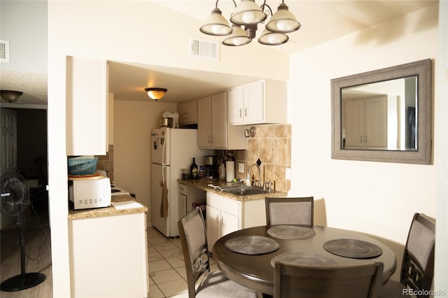 1358 S Irving St Unit A9, Denver, CO 80219 - kitchen with tasteful backsplash, white appliances, a chandelier, and light tile patterned floors