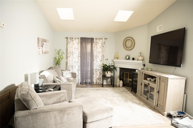 1358 S Irving St Unit A9, Denver, CO 80219 - living room featuring a skylight, vaulted ceiling, a glass covered fireplace, and light wood finished floors