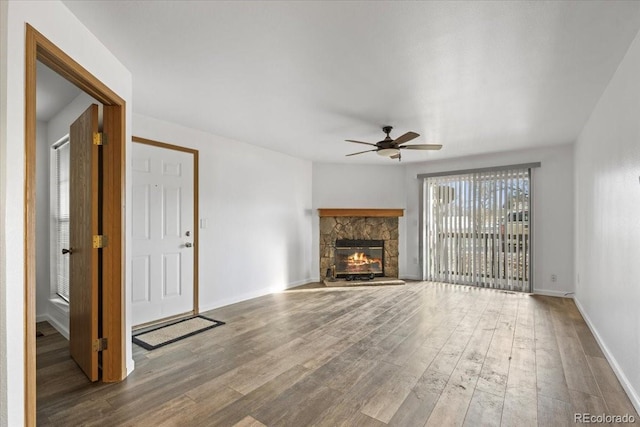 unfurnished living room with wood-type flooring, ceiling fan, and a fireplace