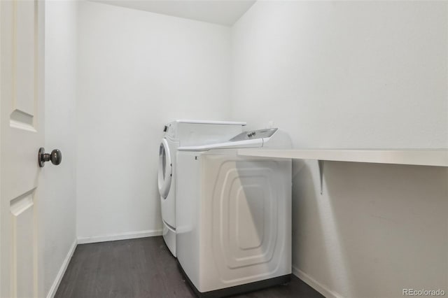 laundry area featuring dark wood-type flooring, washer and dryer, laundry area, and baseboards
