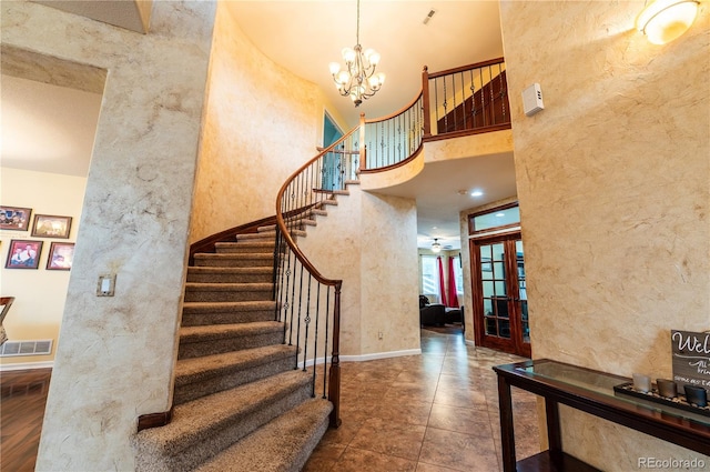 3902 Eagle Tail Ln, Castle Rock, CO 80104 - stairway with a textured wall, a chandelier, a high ceiling, french doors, and baseboards