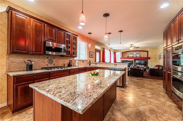 3902 Eagle Tail Ln, Castle Rock, CO 80104 - kitchen featuring appliances with stainless steel finishes, a peninsula, a sink, open floor plan, and a center island
