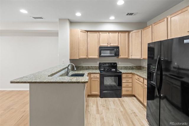 8399 Stonybridge Cir, Highlands Ranch, CO 80126 - kitchen with black appliances, light brown cabinetry, a peninsula, light wood finished floors, and recessed lighting