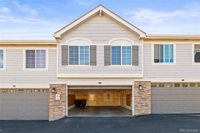 8399 Stonybridge Cir, Highlands Ranch, CO 80126 - view of front of home featuring driveway, an attached garage, and stone siding