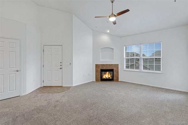 unfurnished living room featuring ceiling fan, light colored carpet, a fireplace, and high vaulted ceiling