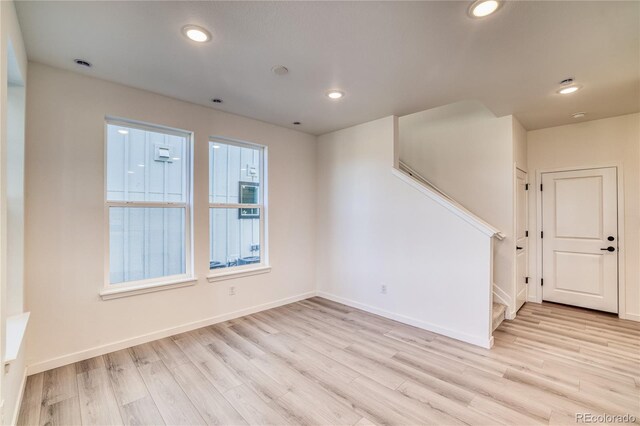 unfurnished room featuring stairs, recessed lighting, and light wood-type flooring