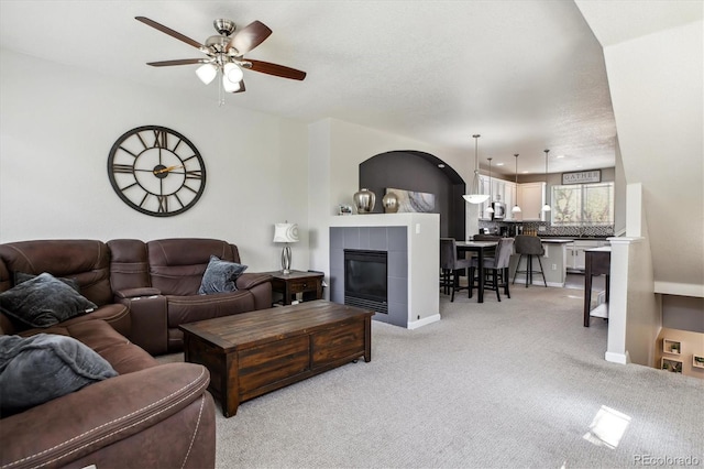 9300 E Florida Ave Unit 1107, Denver, CO 80247 - living room featuring a tile fireplace, light carpet, and ceiling fan