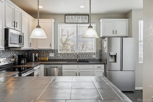 9300 E Florida Ave Unit 1107, Denver, CO 80247 - kitchen with tile counters, a sink, white cabinets, stainless steel appliances, and backsplash