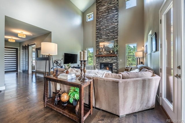 230 S Big Meadow Trl, Franktown, CO 80116 - living area with high vaulted ceiling, a fireplace, dark wood-type flooring, and a barn door